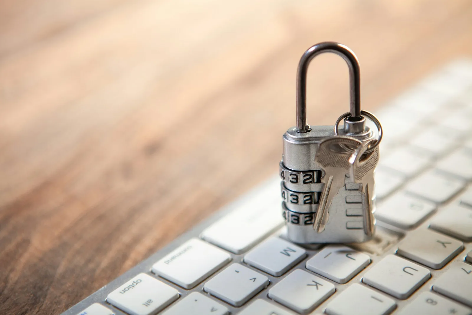 A padlock and keys resting on a computer keyboard, representing access controls applied to children's event photos